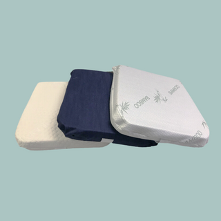 Stack of 100% organic latex seat cushion with organic cotton, denim, and bamboo covers in various colors on a light blue background