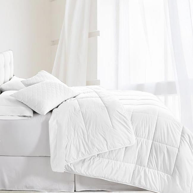 Bedroom showcase that shows the organic filled wool comforter. all white. with stitching pattern